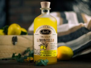 Limoncello bottle with lemons and greens on display