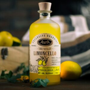 Limoncello bottle with lemons and greens on display